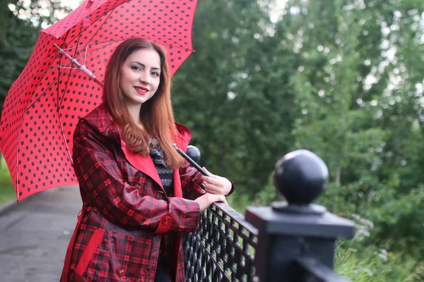 Donna con ombrello rosso su albero di strada — Foto Stock