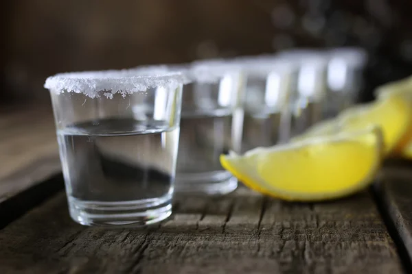 Pile de tequila avec sel et citron sur un fond en bois — Photo