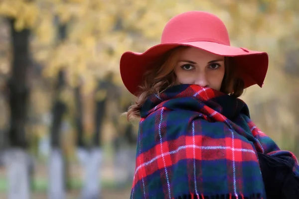 Femme sérieuse en chapeau rouge dans le parc d'automne — Photo