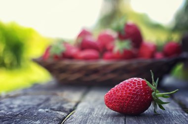 Hasır plaka ahşap arka plan üzerinde çilek