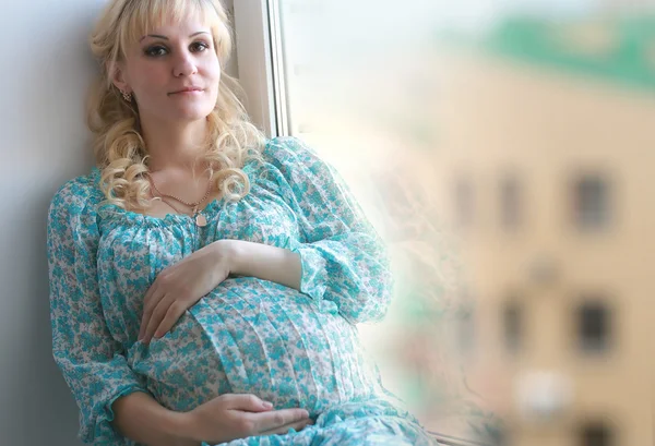 Pancia donna incinta vicino alla finestra — Foto Stock