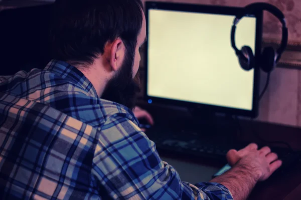 Mann hinter Computer mit Kopfhörer — Stockfoto