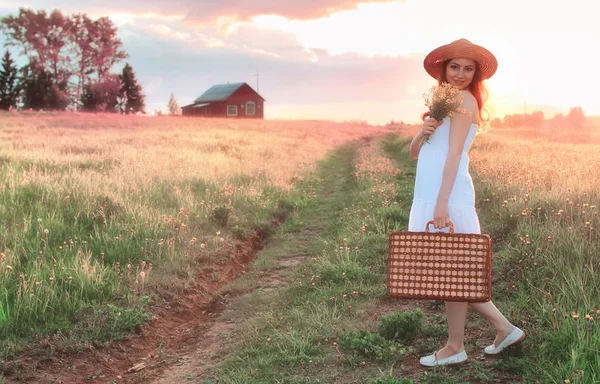 Atardecer verano chica en un campo con flores — Foto de Stock