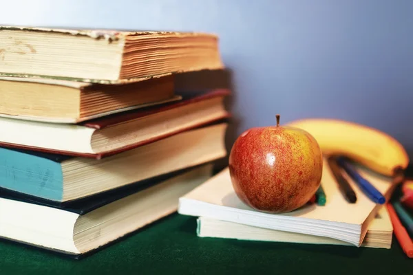 Educação conceito livros pilha, maçã e caneta — Fotografia de Stock