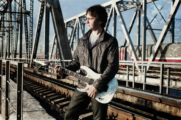 Efeito de arranhão em homens de foto com guitarra em uma estrada de ferro — Fotografia de Stock