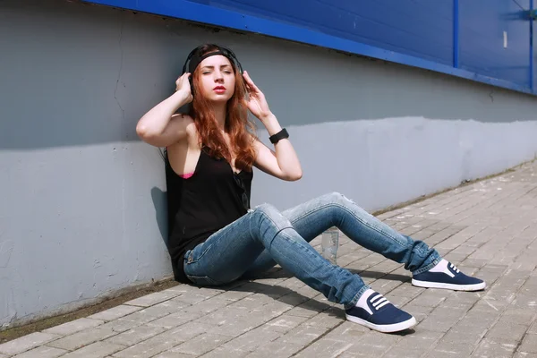 Hipster meisje op de blauwe muur — Stockfoto