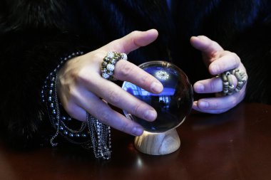 Büyücü bir şeffaf kristal küre fal gelecek için eller.