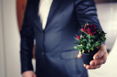 bir pot adam ambarda elinde gül