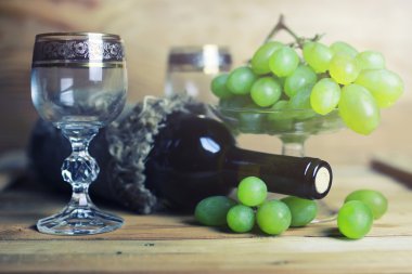 üzüm ve şarap şişesi kitap ile ahşap masa