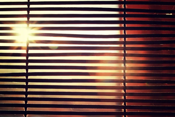 Brilho da luz solar brilhante através das cortinas de madeira Rom — Fotografia de Stock