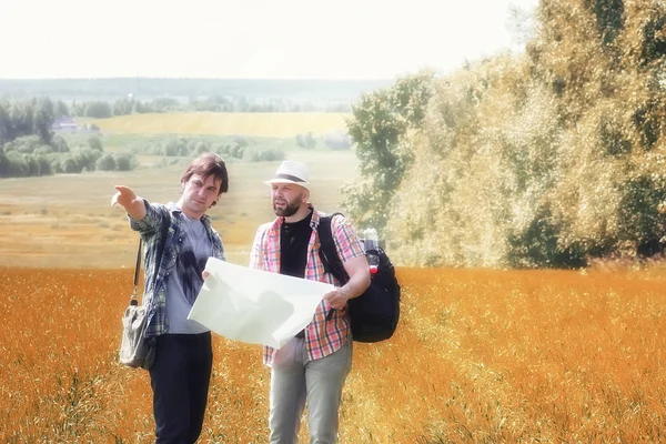 Пара людей с картой в осеннем поле — стоковое фото