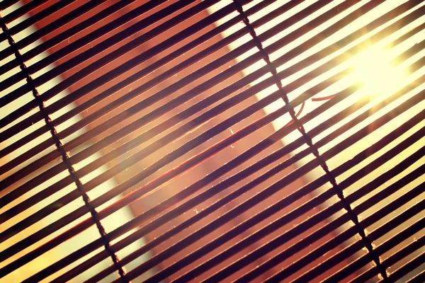 Відблиски від яскравого сонячного світла через дерев'яні римські штори — стокове фото