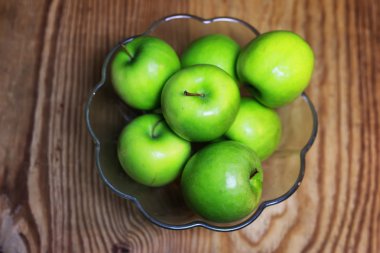 bir cam kase ahşap arka planda yeşil elma