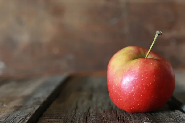 กัดแอปเปิ้ลบนพื้นหลังไม้ — ภาพถ่ายสต็อก