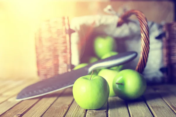 Солнечный свет зеленое яблоко в корзине деревянный фон — стоковое фото