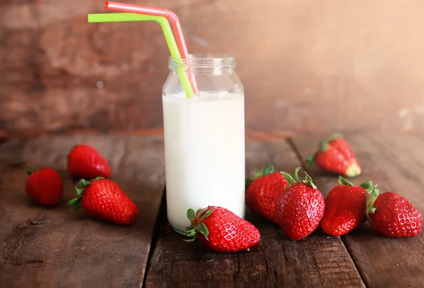 Mesa de madera con fresas y leche en un vaso —  Fotos de Stock