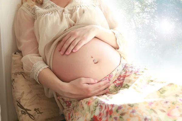 Barriga mulher grávida perto da janela — Fotografia de Stock