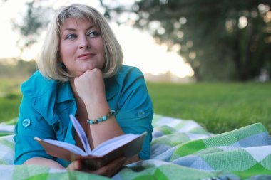 kadınla çimenlerin üzerinde kitapla Park