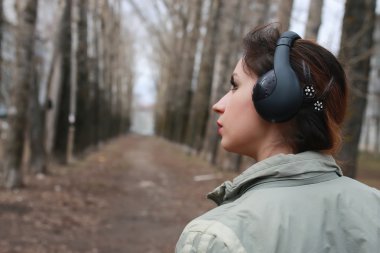 Sonbaharda parkta kulaklıklı bir kadın.