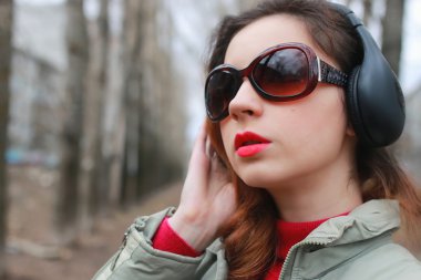 Sonbaharda parkta kulaklıklı bir kadın.