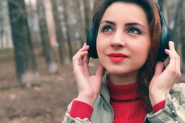 Flicka i parken med hörlurar — Stockfoto