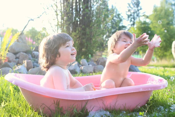 Ikrek fiú és lány fürdővíz szabadban — Stock Fotó