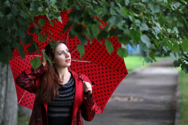 kadın bir yağmurluk ve şemsiye