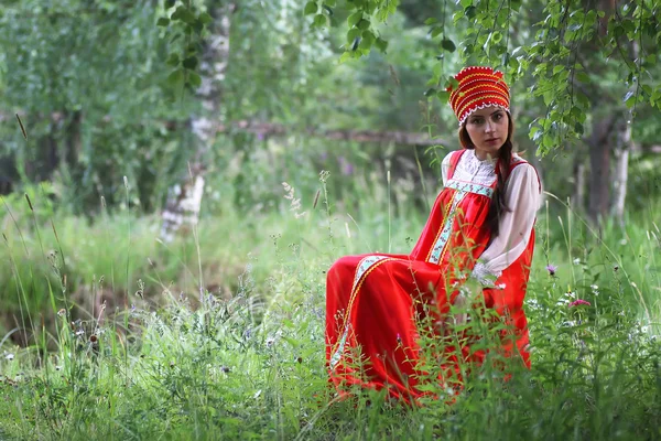Słowianin w tradycyjnym stroju siedzi w przyrodzie — Zdjęcie stockowe