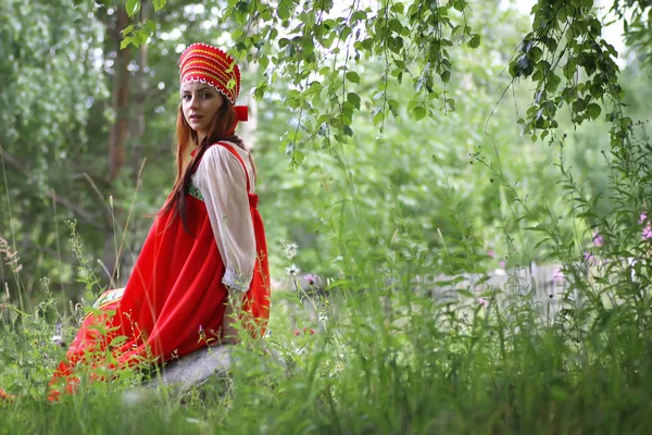 Slavische in traditionele kleding zit in de natuur — Stockfoto