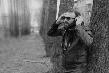 Kulaklıklı, parktaki sakallı adam.