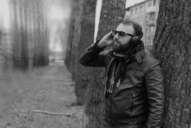 Kulaklıklı, parktaki sakallı adam.