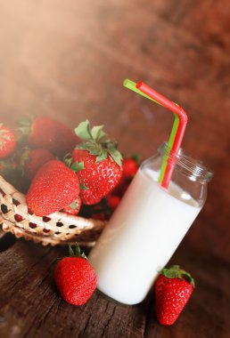 çilek ve bir bardak süt ile ahşap masa