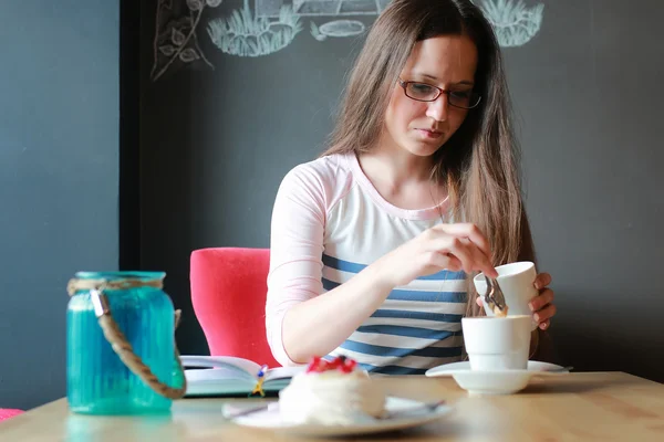 Mädchen in einem Café auf eine Tasse Kaffee mit dem Notizbuch — Stockfoto