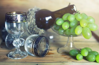 üzüm ve şarap şişesi kitap ile ahşap masa