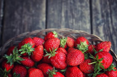 Hasır plaka ahşap arka plan üzerinde çilek