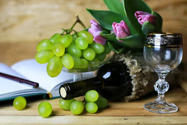 Бутылка вина и стеклянный виноград — стоковое фото