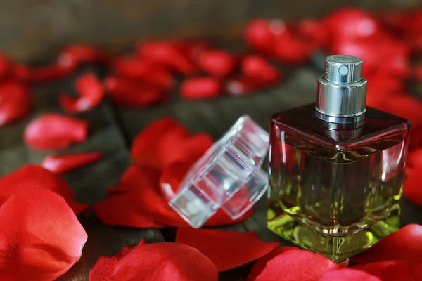 Perfume bottle and petals — Stock Photo, Image