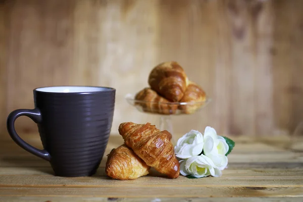 Taza croissant desayuno fondo de madera — Foto de Stock