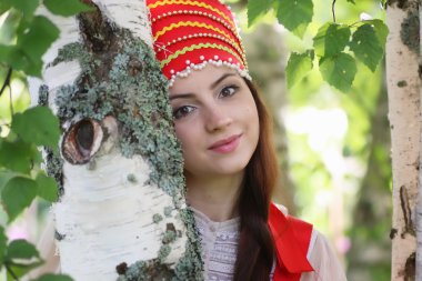 Slav geleneksel elbise ağaçların arkasında saklanıyor