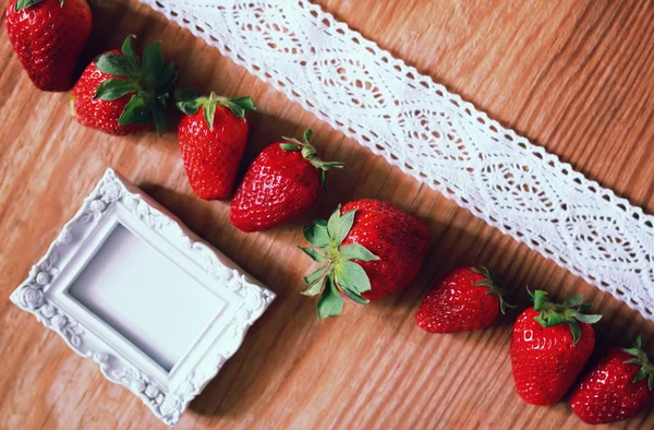 Aardbeien top op houten en kant — Stockfoto