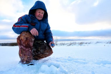 Göl kenarında balıkçı kış