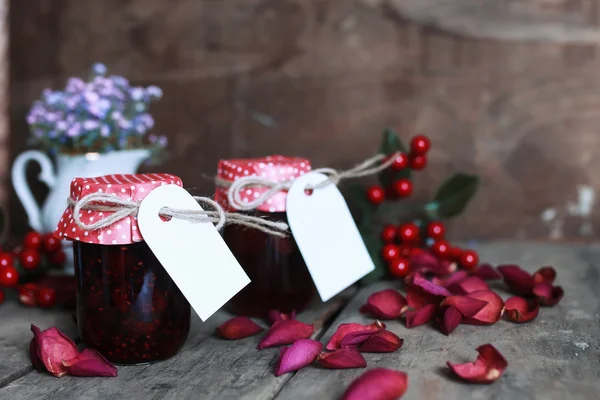 Rustic homemade jam jar wooden background and flower — Stock Photo, Image