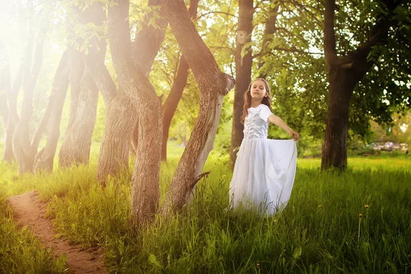 Jovem menina em um vestido branco contra uma árvore no outono — Fotografia de Stock