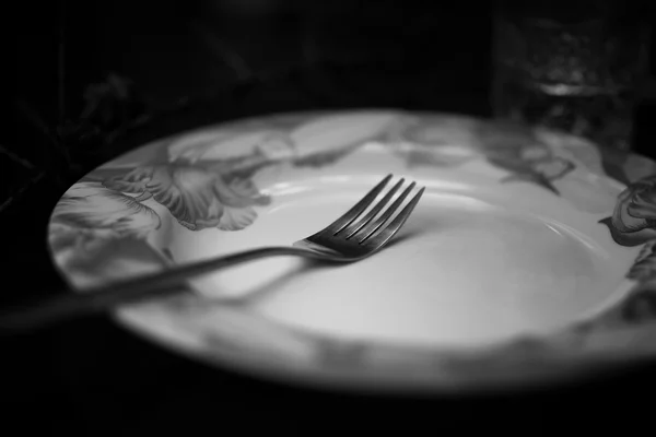 Tenedor en plato negro blanco —  Fotos de Stock