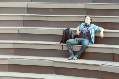 Dışarıda tek başına oturan bir adam var.