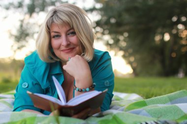 kadınla çimenlerin üzerinde kitapla Park