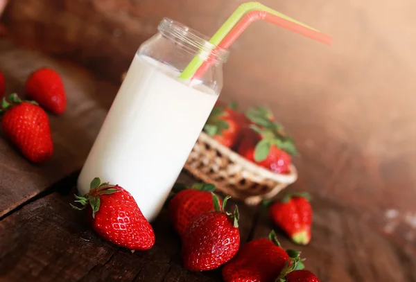 Mesa de madera con fresas y leche en un vaso — Foto de Stock