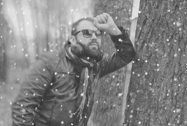 Barba de inverno homem no parque com fone de ouvido — Fotografia de Stock