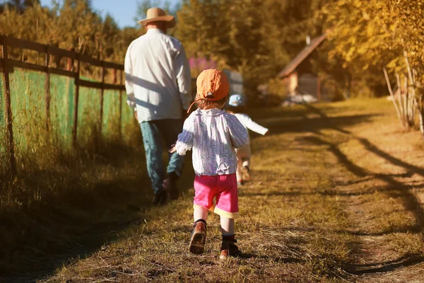 Barnen går med farfar i sommar — Stockfoto