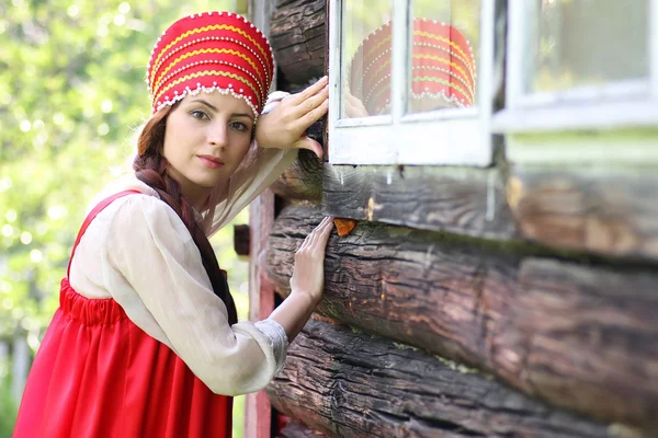 Mujer eslava en la pared de madera vestido tradicional — Foto de Stock